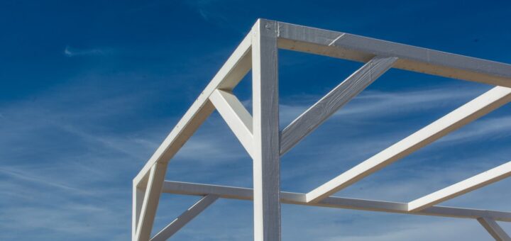 A white wooden structure with a blue sky in the background