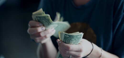 focus photography of person counting dollar banknotes
