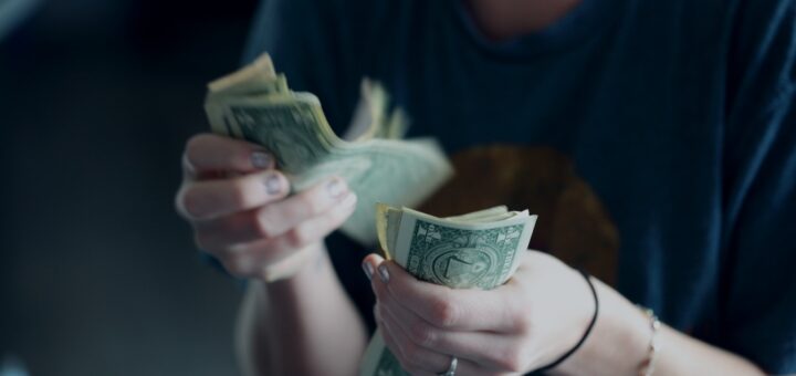 focus photography of person counting dollar banknotes