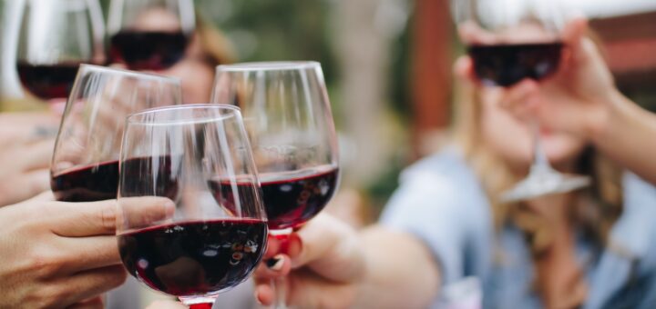 people tossing their clear wine glasses